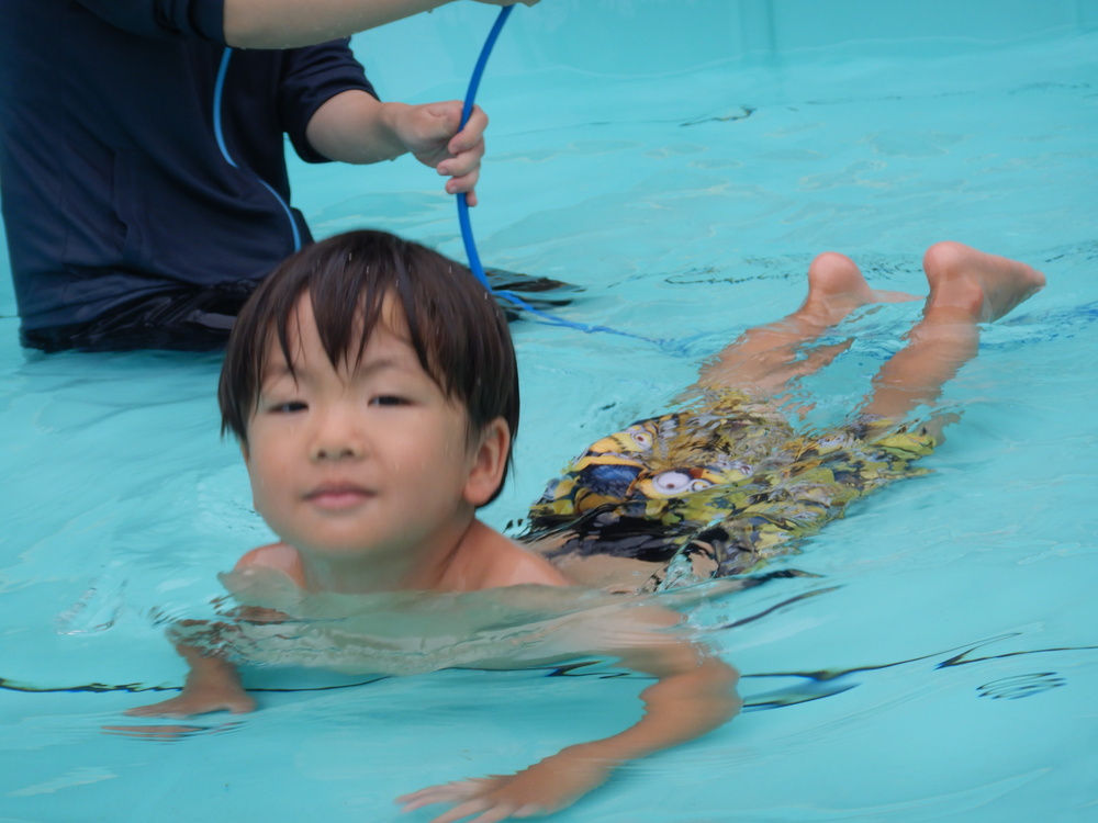 フラフープの中をくぐる男の子