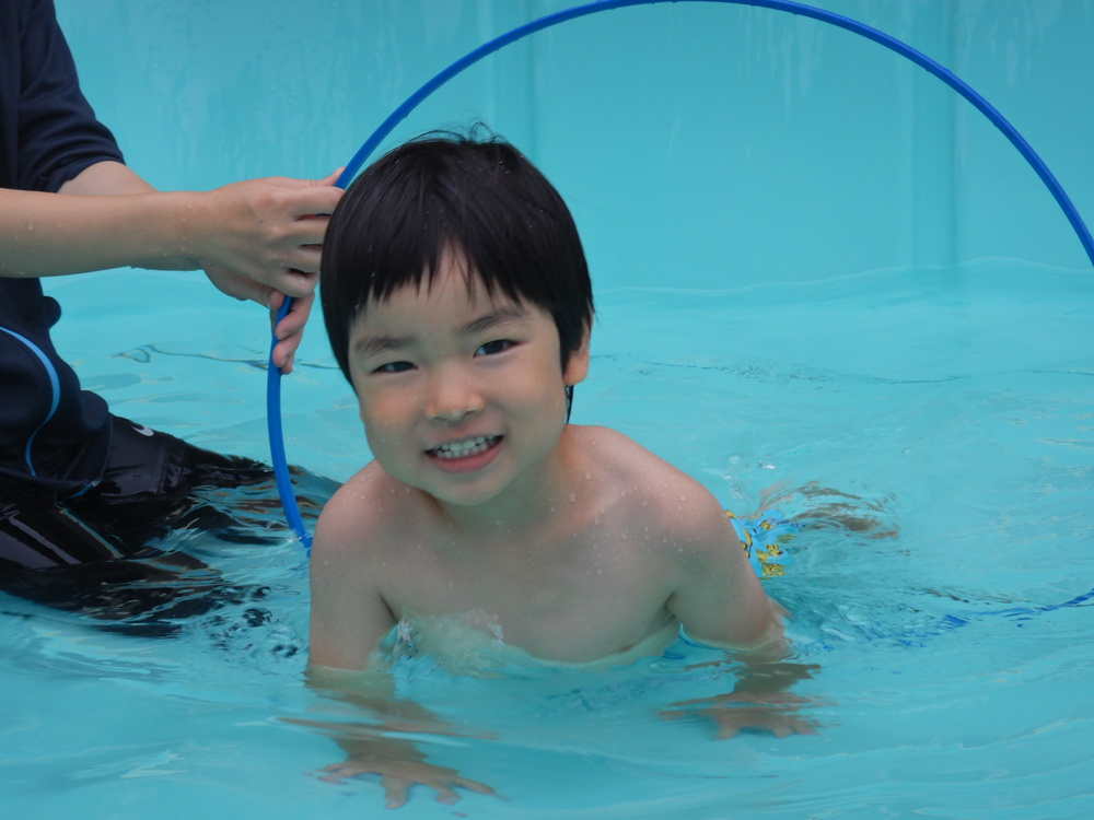 フラフープの中をくぐる男の子