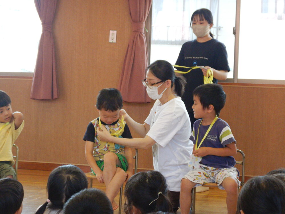 園長先生からメダルをもらっている