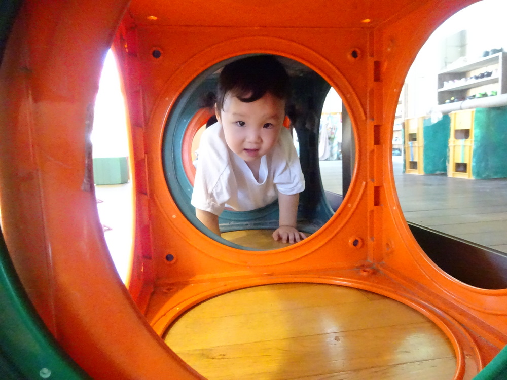 カラーボックスのトンネルで遊ぶ子ども (2)