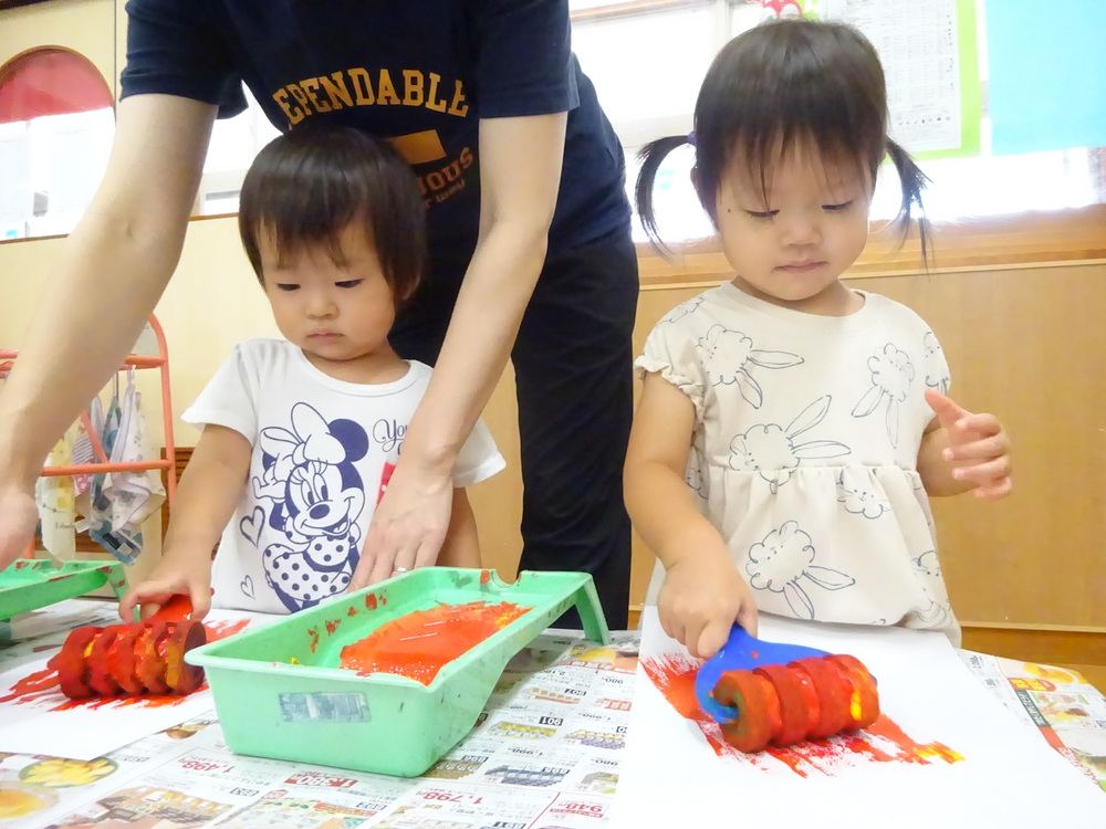 ローラーで色を塗っている子どもたち