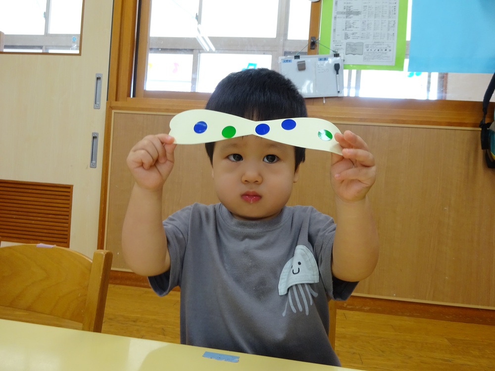 シール貼りをしたものを見せている子ども (1)