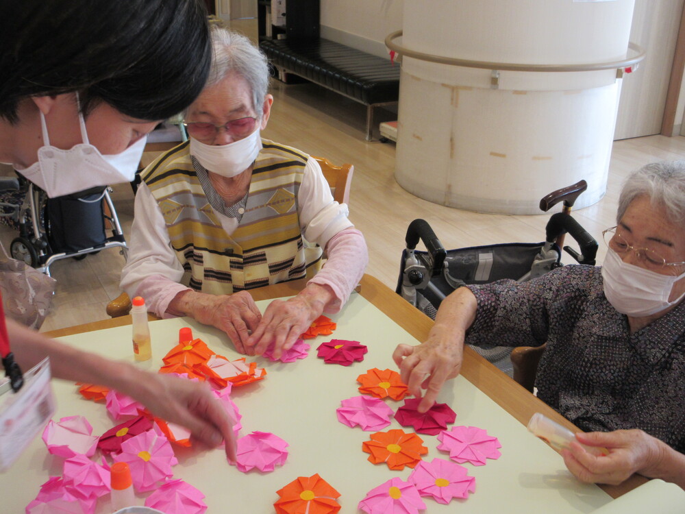 コスモスの花を模造紙に貼ってる様子