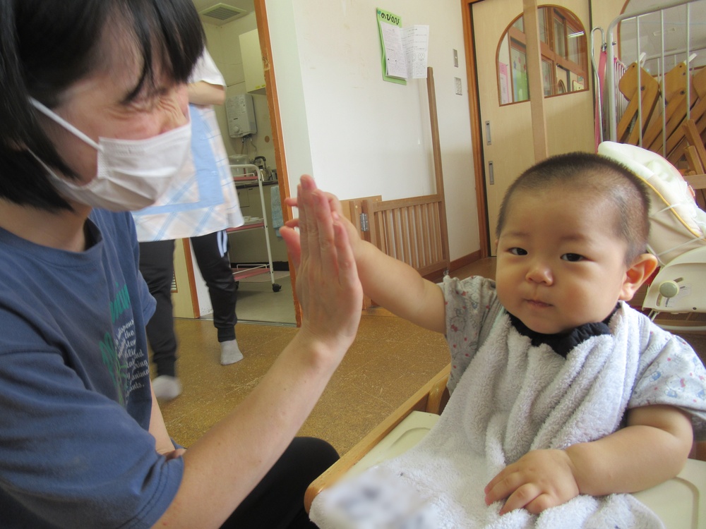 保育者とハイタッチをする子ども