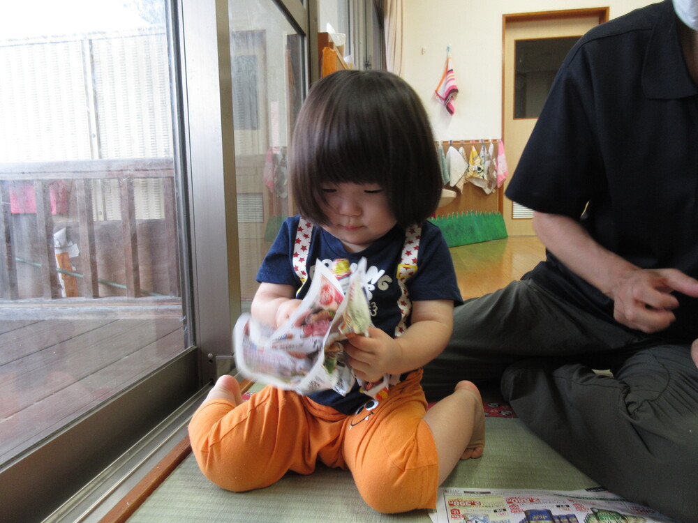 広告紙を丸めている
