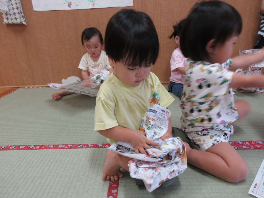 広告紙を丸めている