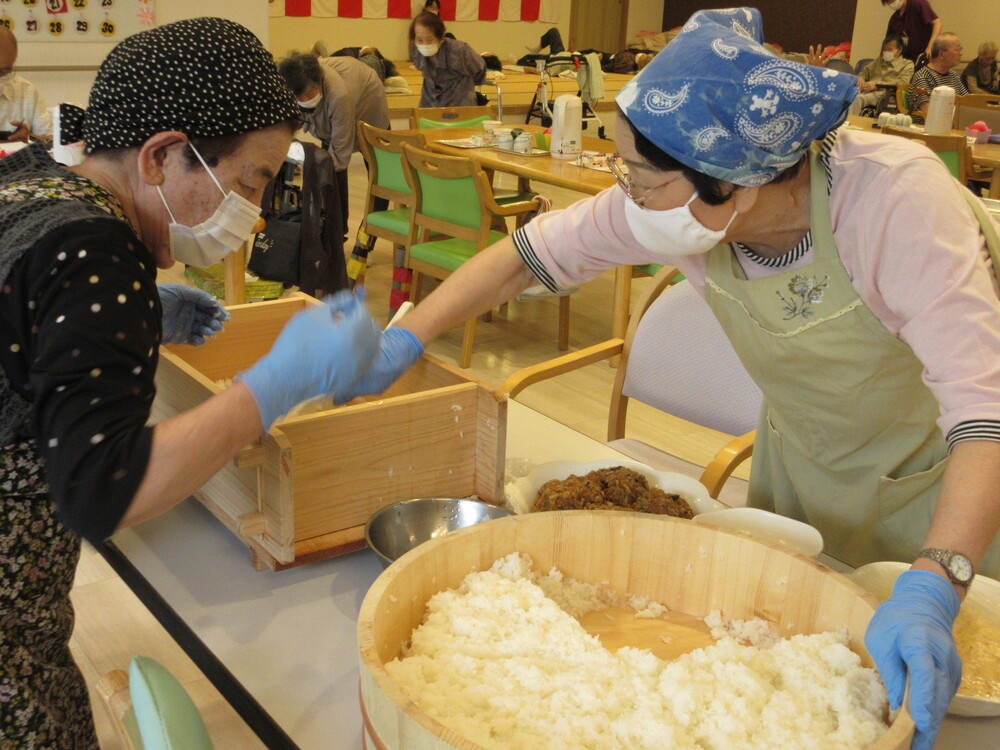 箱寿司の型にご飯を入れる様子