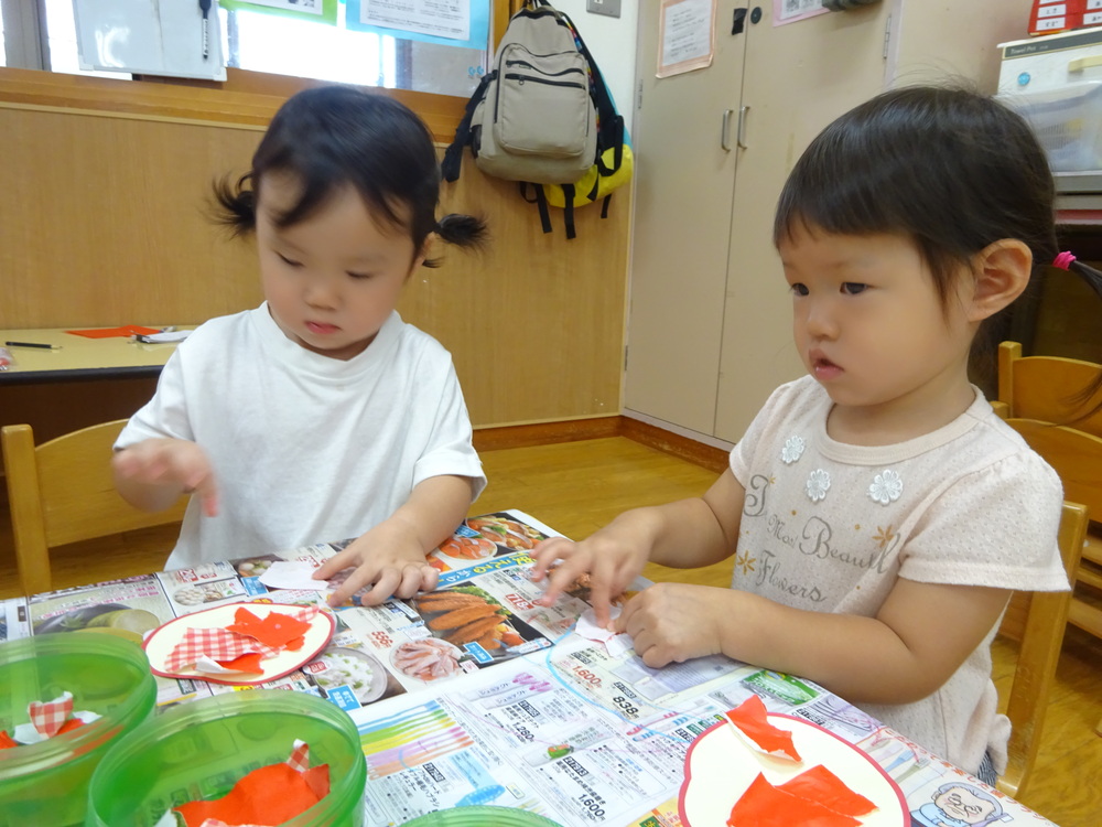 折り紙を使ってりんごを作っている子どもたち (2)