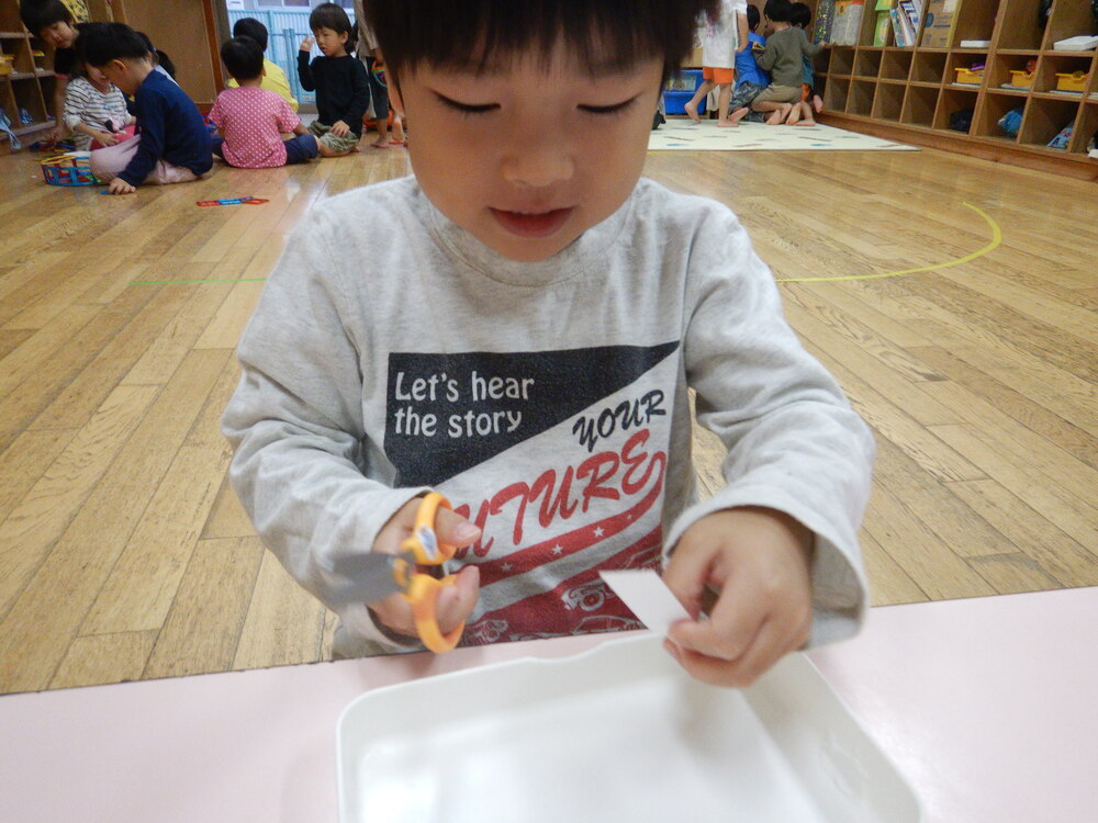 ハサミで画用紙を切る