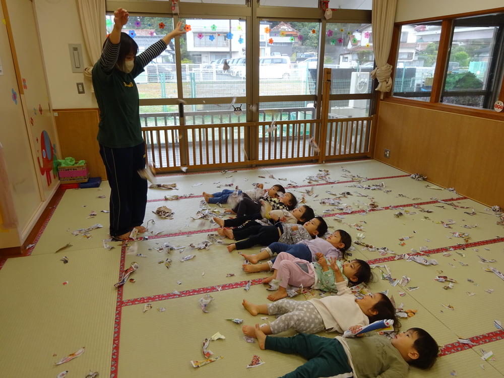 広告紙のシャワーを楽しんでいる子どもたち (1)
