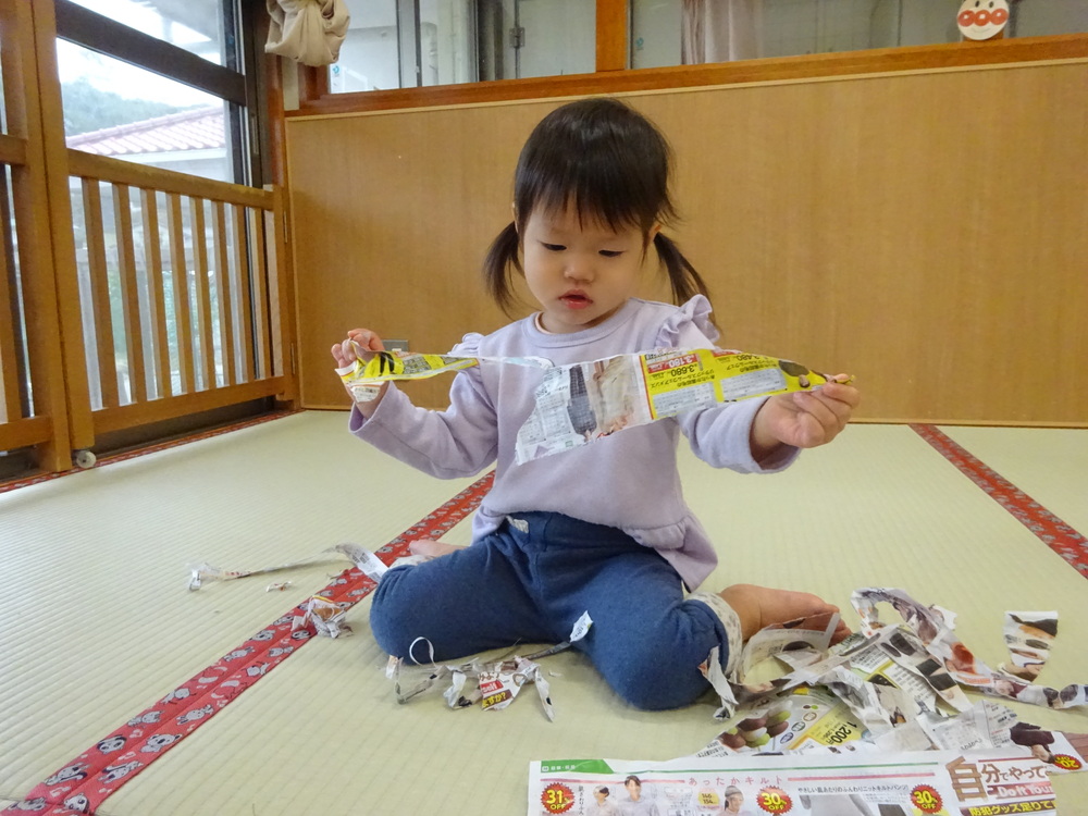 広告紙をちぎっている子ども (2)