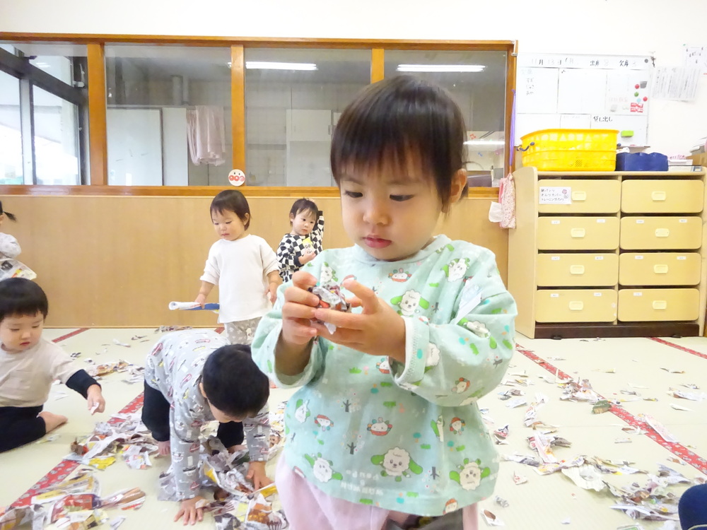 広告紙を丸めている子ども