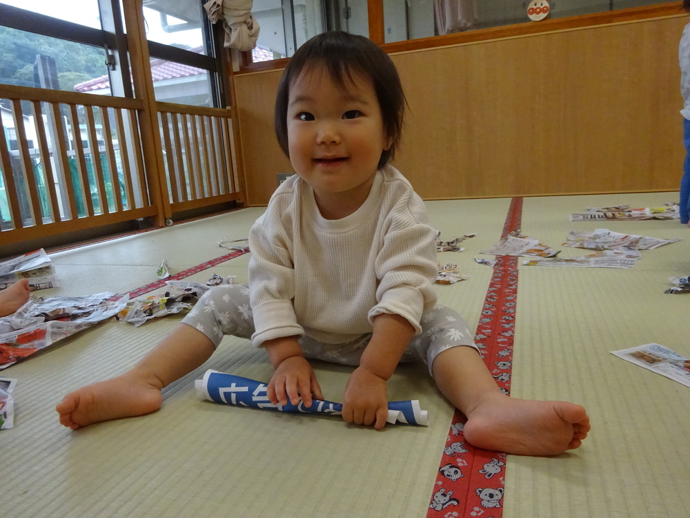 広告紙を棒にしている子ども