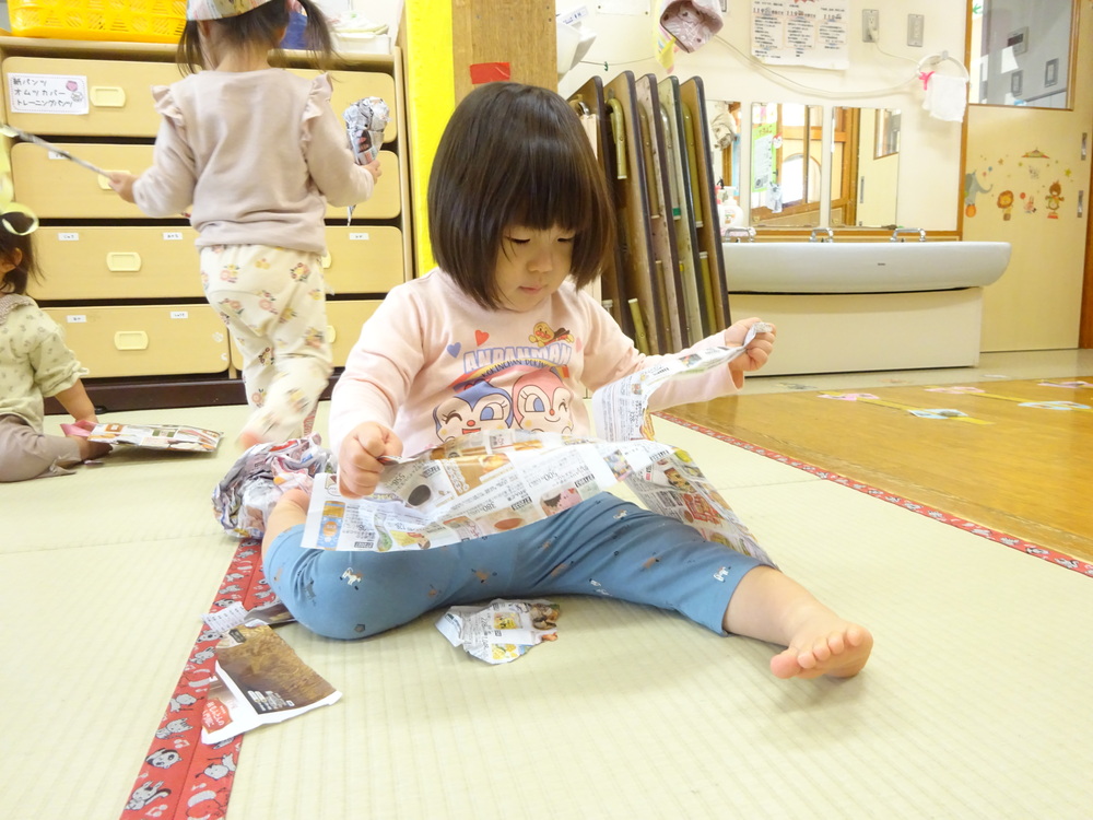 広告紙で遊んでいる子どもたち (7)