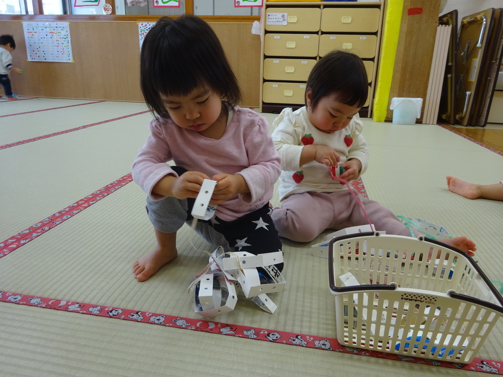 紐通しをして遊ぶ子ども (1)