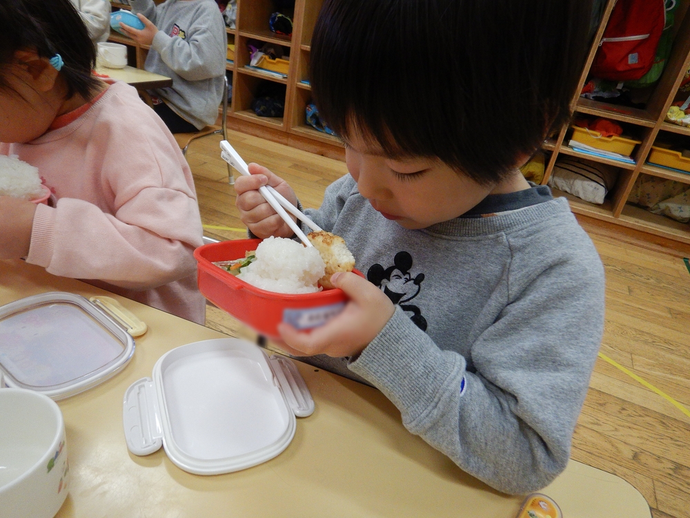 お弁当を食べる男の子