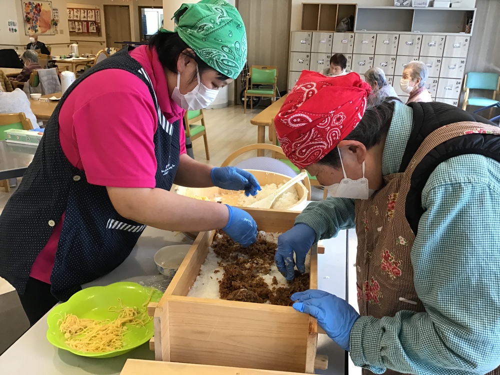 箱寿司に具材を入れている様子