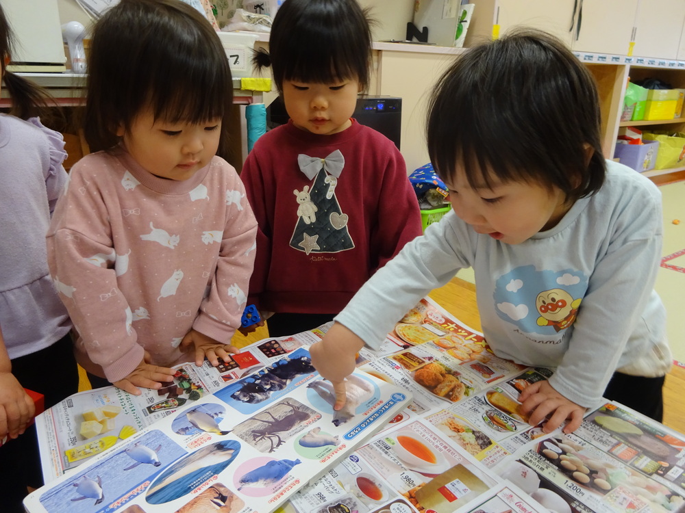図鑑で白くまを見ている子どもたち