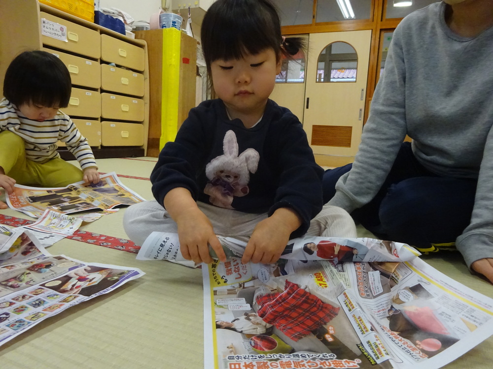 広告紙遊びをしている子ども (2)