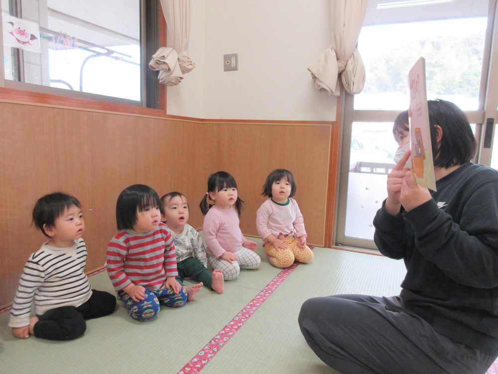 ひな祭りの紙芝居を見る子ども