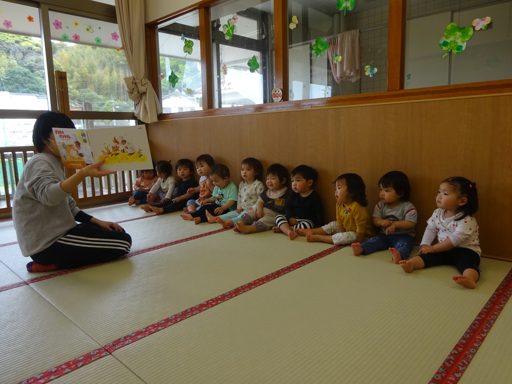絵本を読んでもらう子どもたち