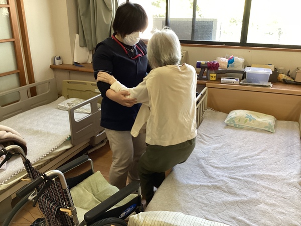 車椅子からベッドへ移っています