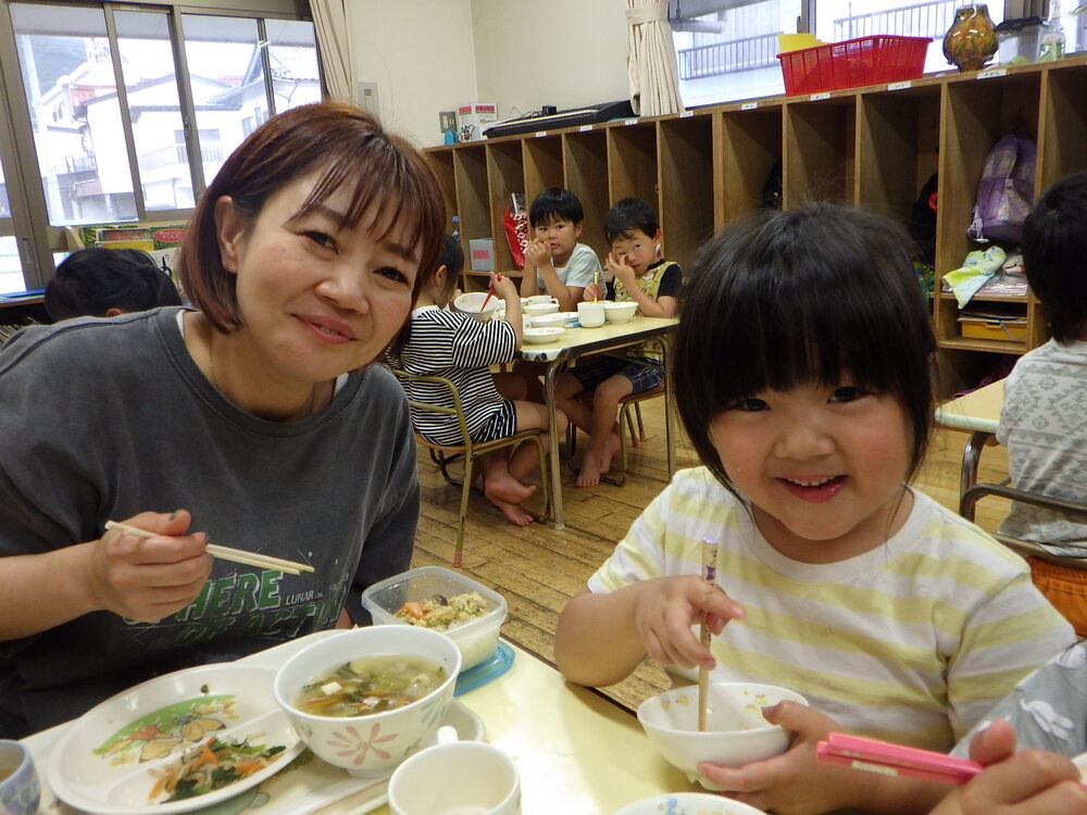 一日保育士のお母さんと一緒に給食を食べている
