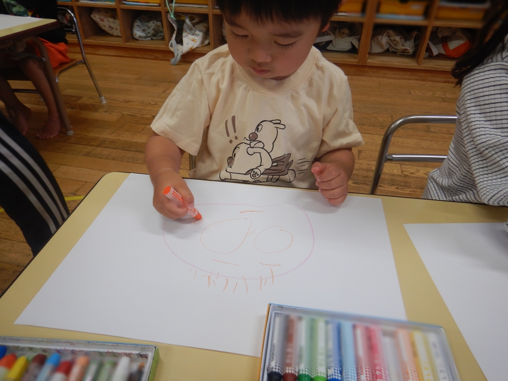 用紙に顔を描く男の子