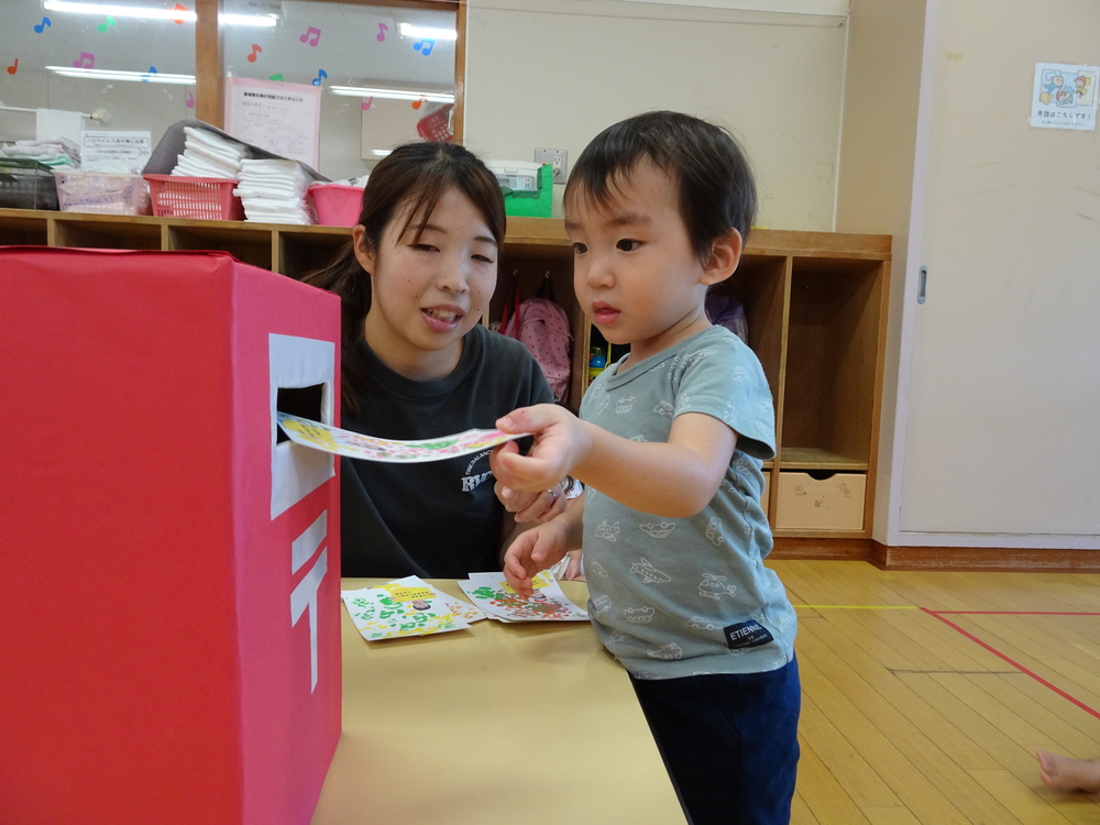 ポストにはがきを入れる子ども (2)