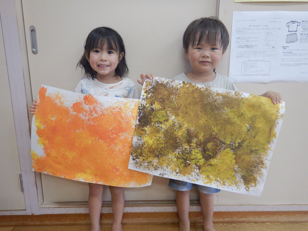 完成した色の着いた画用紙を持っている子どもたち
