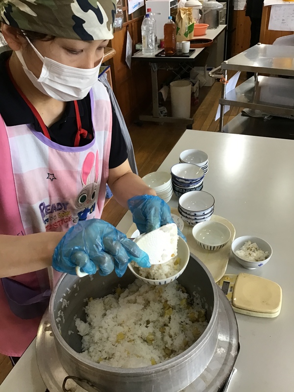 ご飯をよそっています