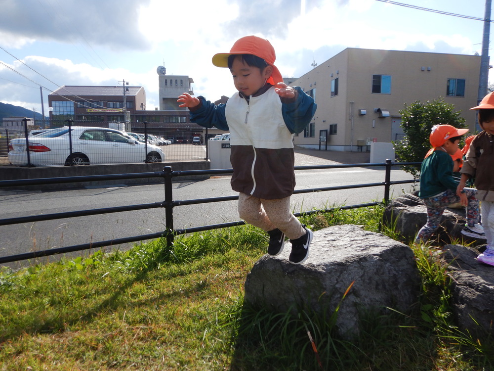 石からジャンプする男の子