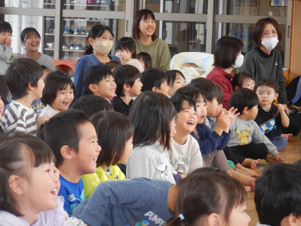 保育者の出し物を見て喜ぶ子どもたち