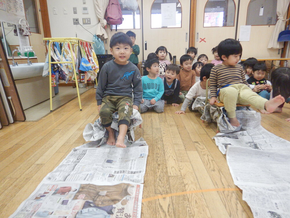 新聞紙の上を走るゲームをしている様子 (1)