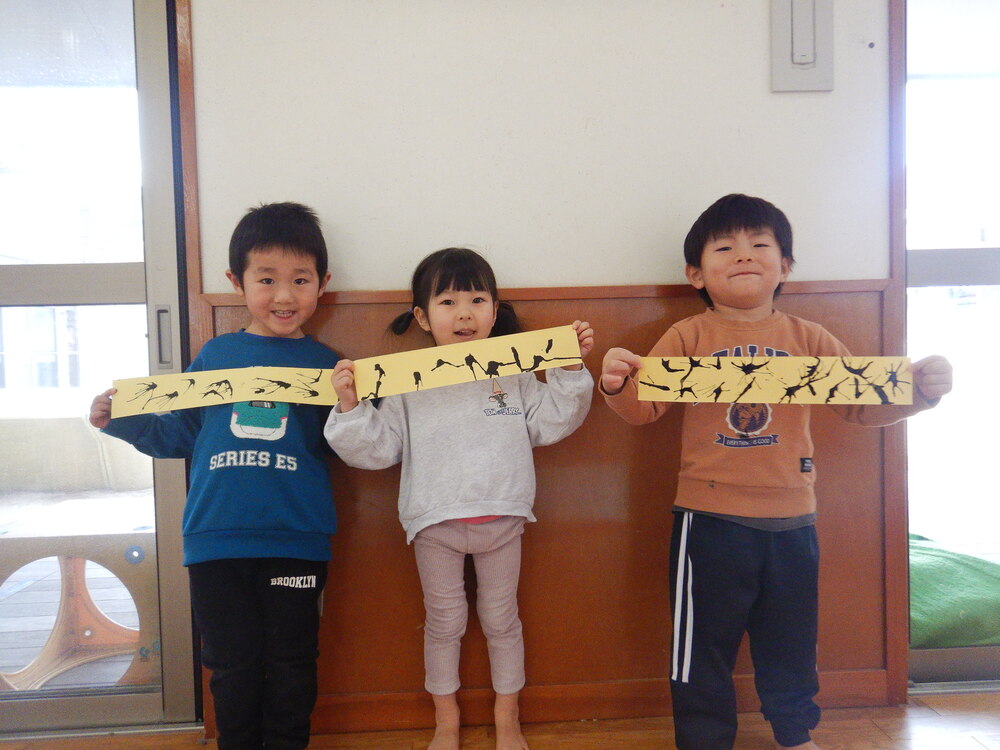 吹き絵をしたものを見せている子どもたち