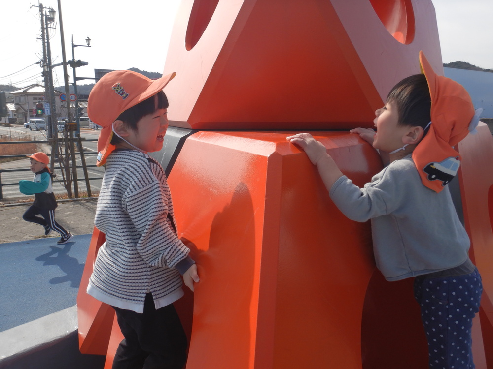 オレンジのオブジェで笑いあっている様子