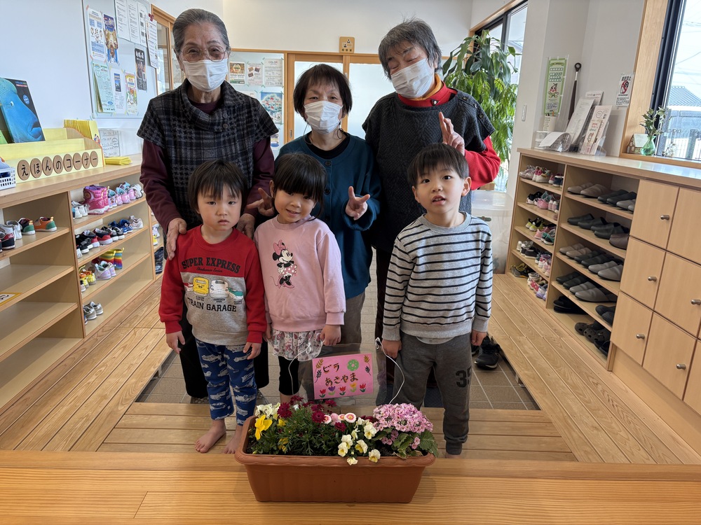 花と利用者さんと園児