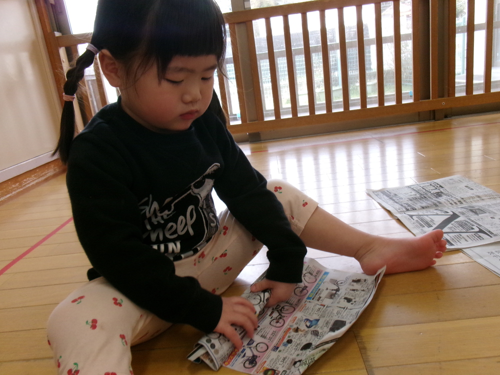 新聞紙で遊ぶ子ども