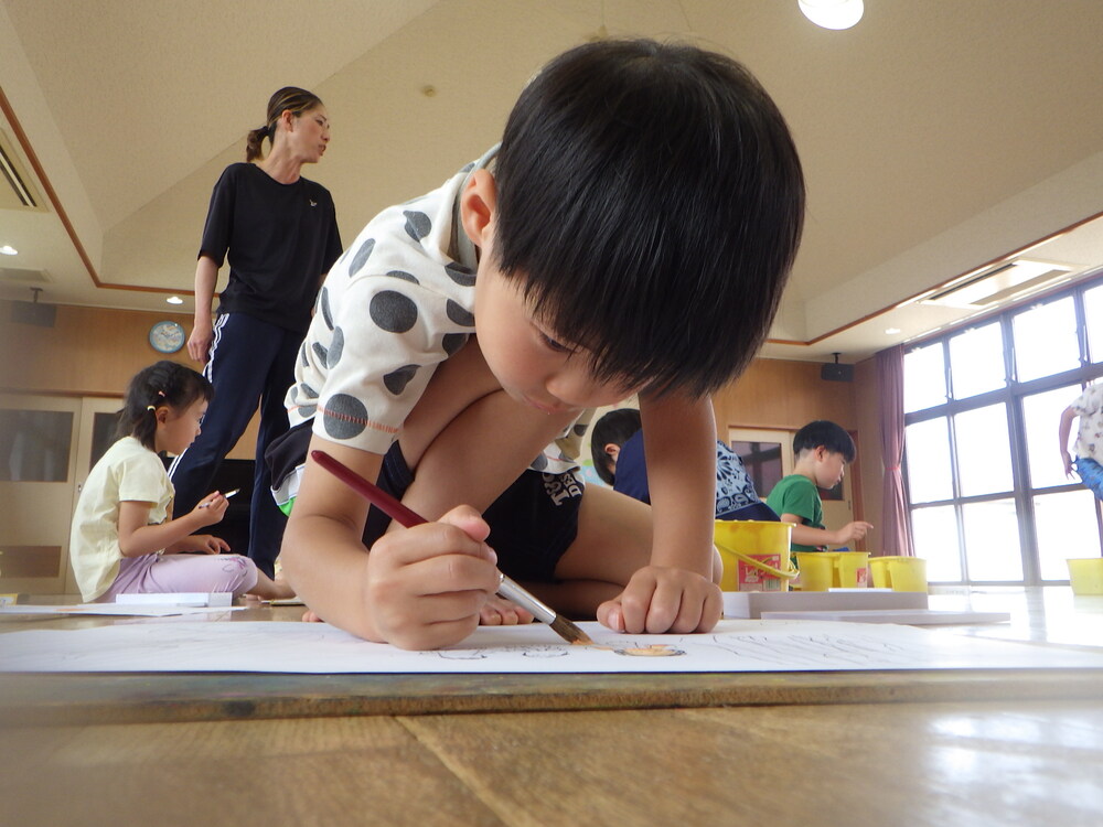 絵に色塗りをする子ども (2)
