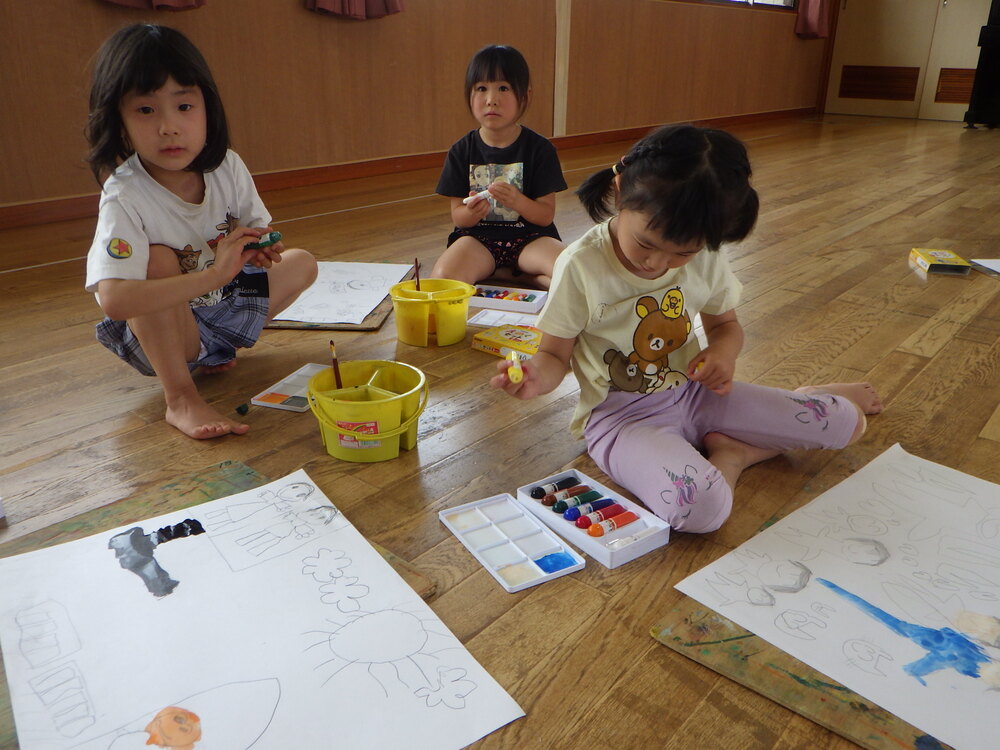 絵に色塗りをする子ども (3)