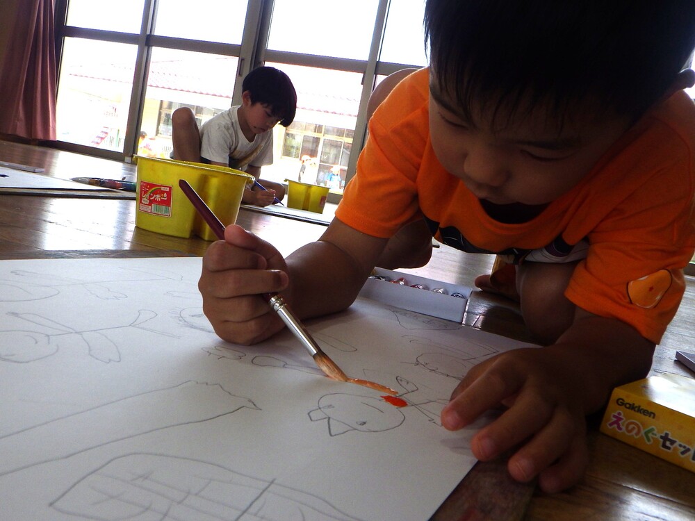 絵に色塗りをする子ども (1)
