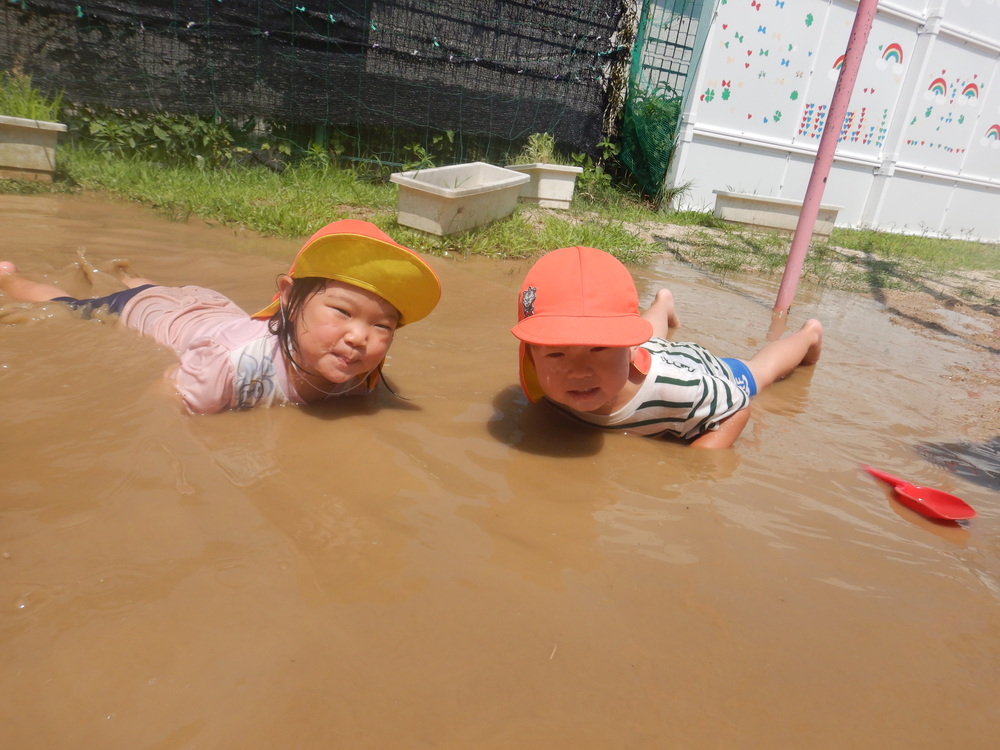 水たまりに寝そべる子どもたち