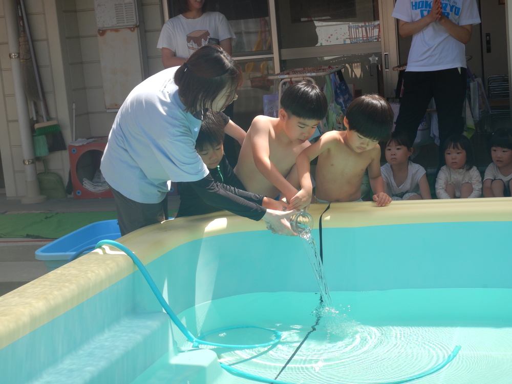 魔法の水を入れている子どもたち