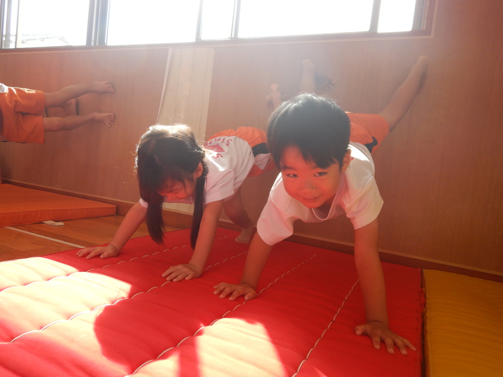 壁倒立の練習をする子ども