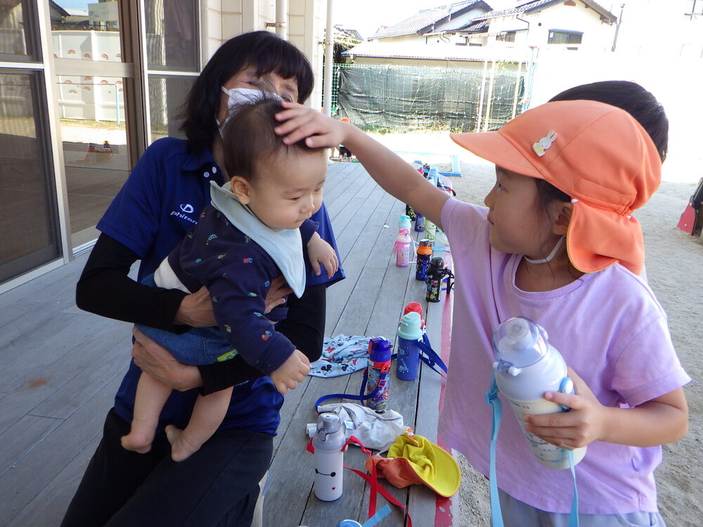 赤ちゃんをあやす子ども