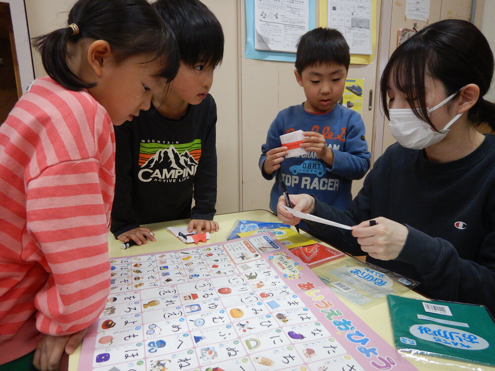 ひらがな表を見ながら、書いている様子