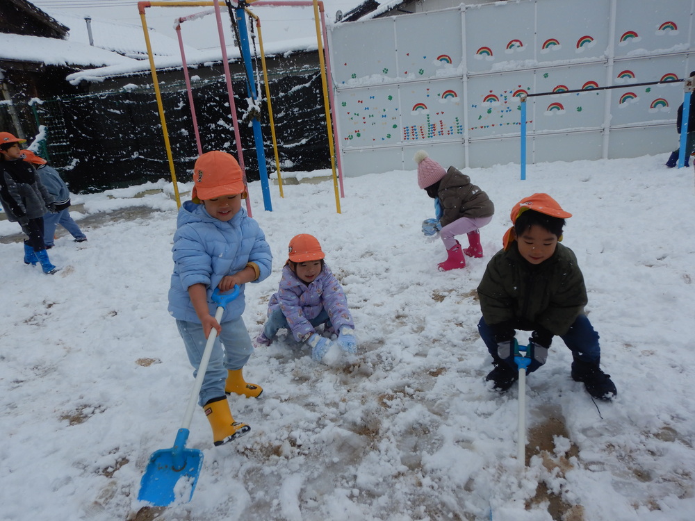 スコップで雪をすくっている様子