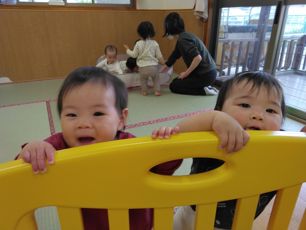 柵越しに笑う子ども