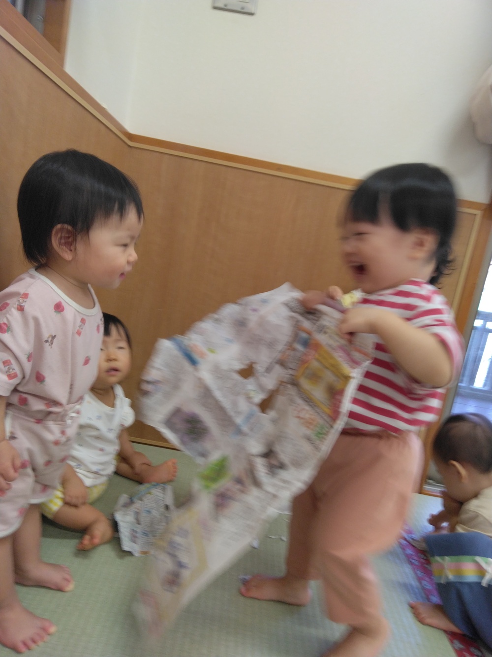 新聞紙で遊ぶ子ども⑵