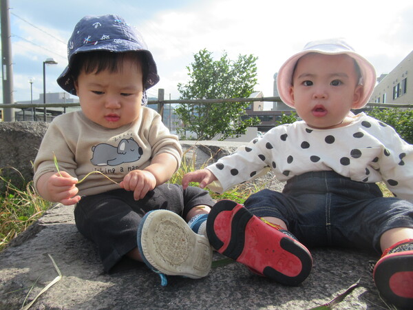 石の上にお友だちを一緒に座る子ども達